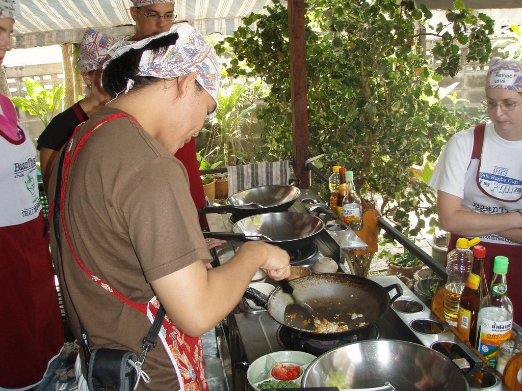 Tourists learning to make Thai dishes from scratch during cooking class