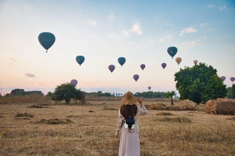 woman-field-hot-air-balloons-5628426