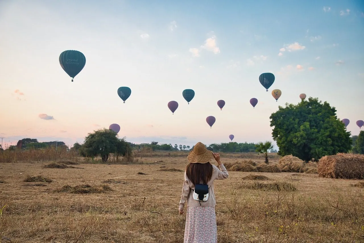 woman-field-hot-air-balloons-5628426