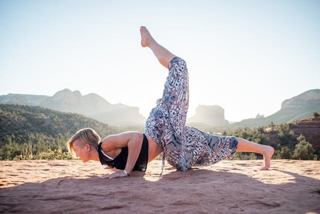 Woman doing One Legged Chin Stand in nature