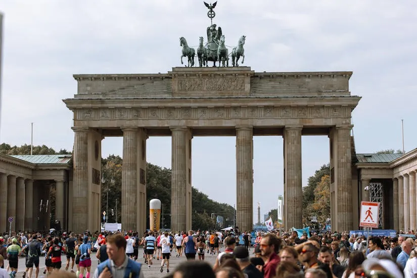 Brandenburg Gate with marathon participants and crowds in Berlin, Germany.