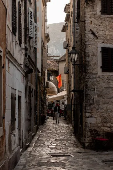 Explore the historic charm of Kotor's narrow cobblestone street with ancient stone buildings.