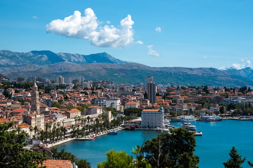 Vibrant aerial view of Split, Croatia, showcasing the coastline, harbor, and surrounding mountains.